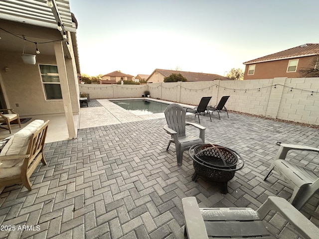 view of patio / terrace with a fenced in pool and an outdoor fire pit