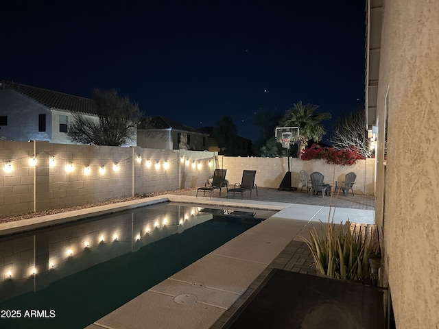 view of pool at twilight