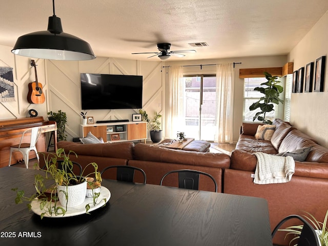 living room featuring a textured ceiling and ceiling fan