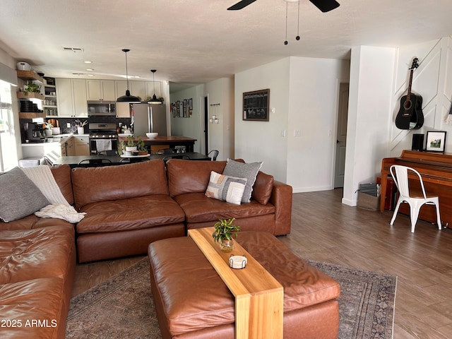 living room with wood-type flooring and ceiling fan