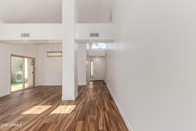 interior space with a towering ceiling, dark hardwood / wood-style floors, and washer / clothes dryer