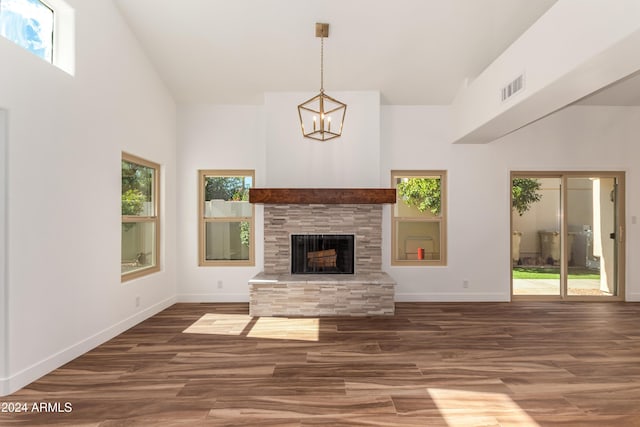 unfurnished living room featuring a tiled fireplace, dark hardwood / wood-style floors, and a towering ceiling