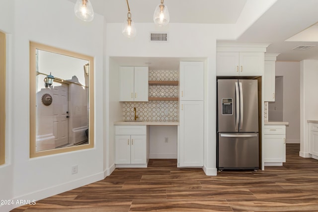 kitchen featuring sink, stainless steel refrigerator with ice dispenser, tasteful backsplash, white cabinets, and decorative light fixtures