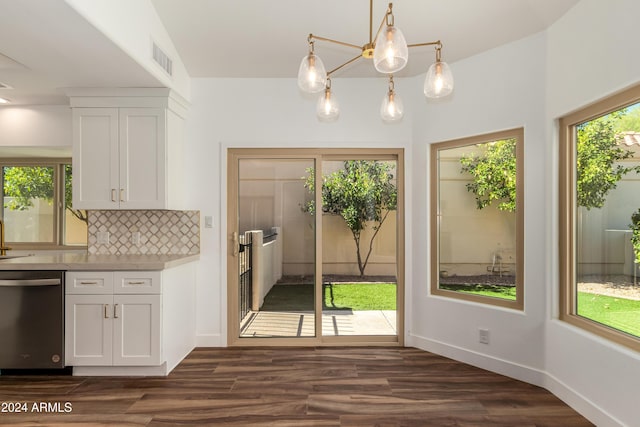 kitchen featuring dark wood-type flooring, white cabinetry, decorative light fixtures, decorative backsplash, and stainless steel dishwasher