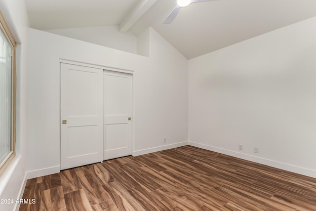 unfurnished bedroom featuring vaulted ceiling with beams, dark wood-type flooring, ceiling fan, and a closet