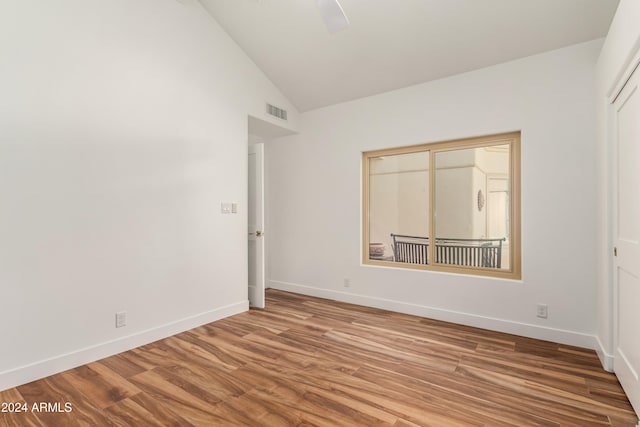 unfurnished bedroom featuring vaulted ceiling, hardwood / wood-style floors, ceiling fan, and a closet