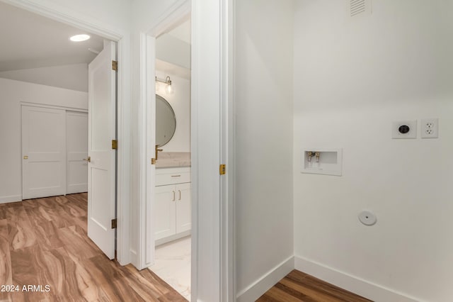 laundry room featuring hookup for a gas dryer, hookup for a washing machine, light hardwood / wood-style floors, and hookup for an electric dryer