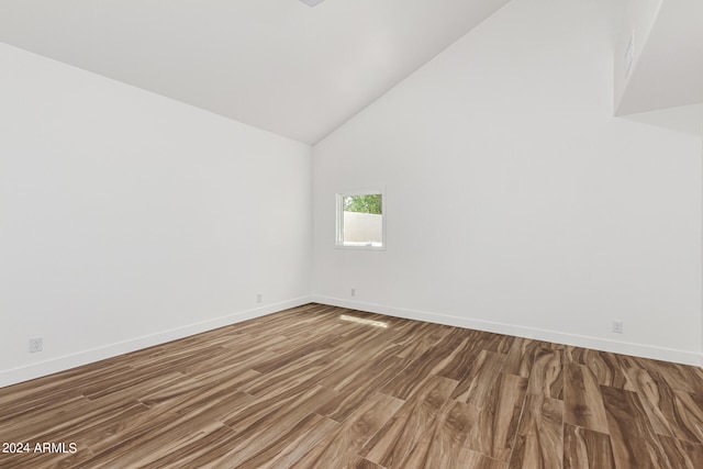 empty room featuring hardwood / wood-style floors and vaulted ceiling