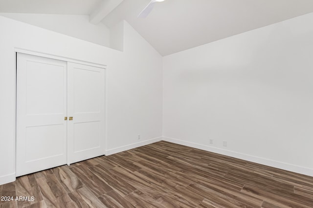 unfurnished bedroom featuring ceiling fan, dark hardwood / wood-style floors, lofted ceiling with beams, and a closet