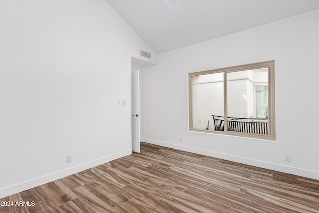 empty room featuring high vaulted ceiling and light hardwood / wood-style floors