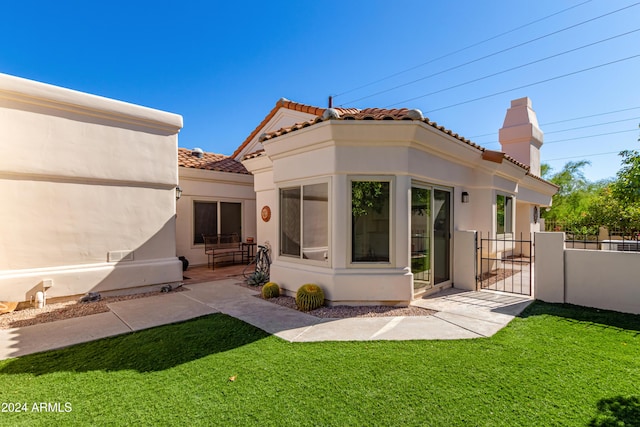 back of house featuring a lawn