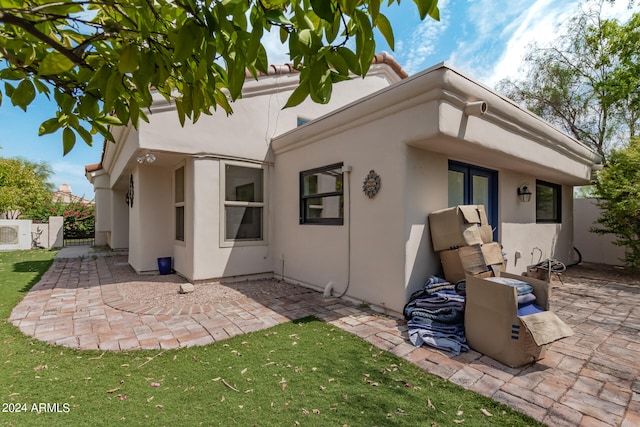 rear view of house featuring a yard and a patio area