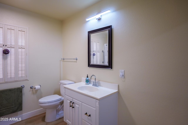 bathroom with hardwood / wood-style flooring, vanity, and toilet