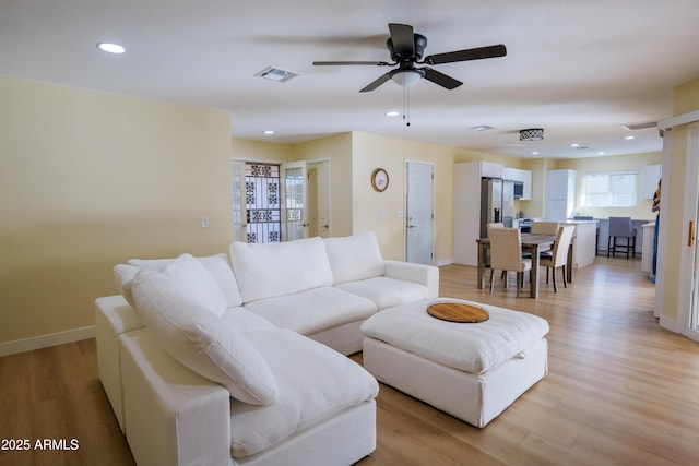 living room with ceiling fan and light wood-type flooring