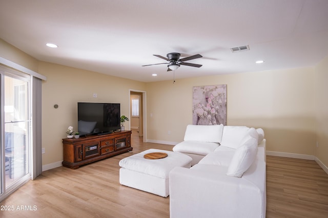 living room featuring ceiling fan and light hardwood / wood-style floors