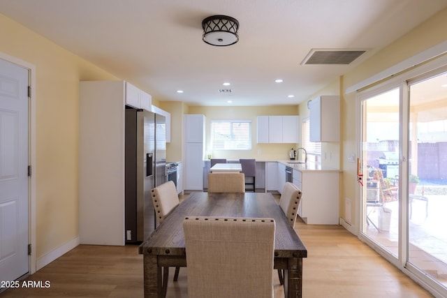 dining room with sink and light hardwood / wood-style floors