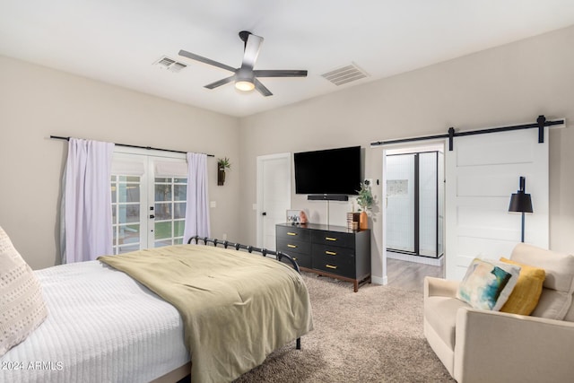 carpeted bedroom with a barn door, ceiling fan, and french doors