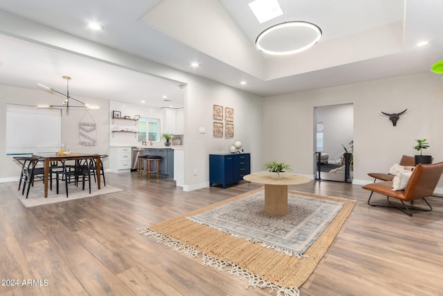 living room featuring a tray ceiling, hardwood / wood-style floors, and a notable chandelier