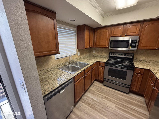 3434 W Danbury Dr Unit A206, Phoenix, AZ 85053 - kitchen with stainless steel appliances, crown molding, light wood-type flooring, decorative backsplash, and light stone counters