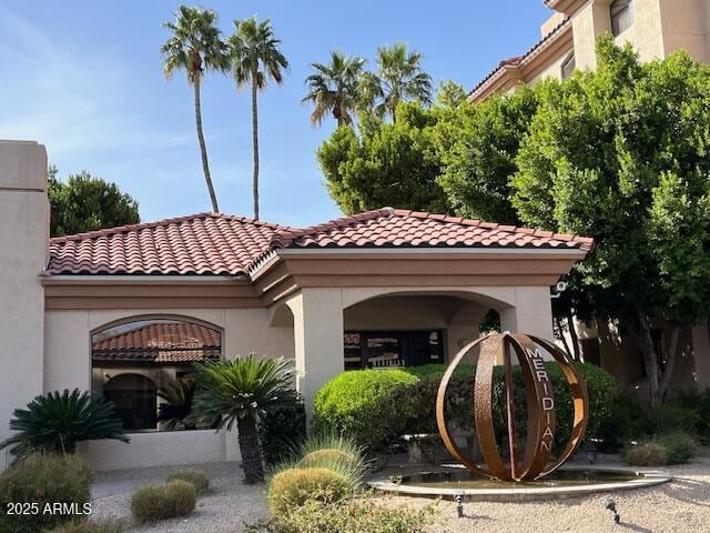 view of front of home with a tiled roof and stucco siding