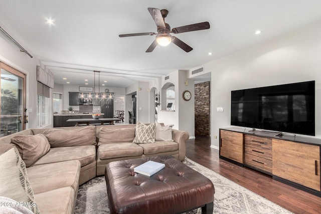 living room with wood finished floors, visible vents, recessed lighting, arched walkways, and ceiling fan