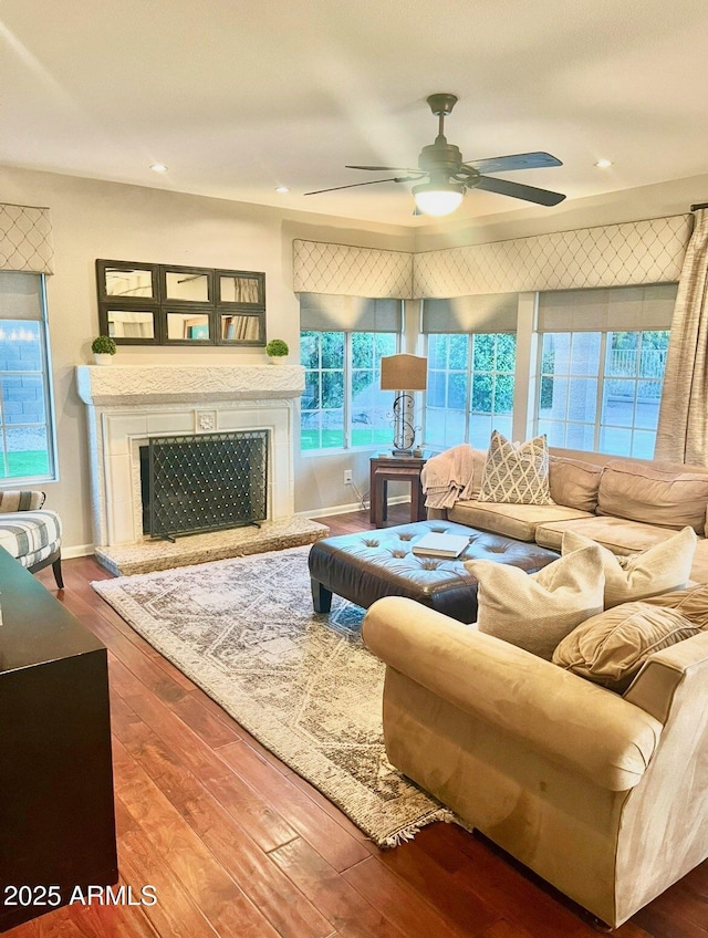 living room featuring a ceiling fan, wood finished floors, recessed lighting, and a fireplace with raised hearth