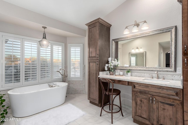 bathroom with vanity, a freestanding tub, and tile patterned flooring