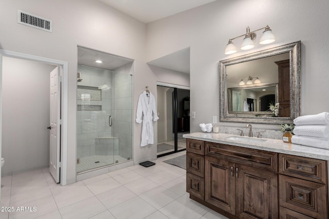 full bathroom featuring vanity, visible vents, a stall shower, tile patterned floors, and toilet