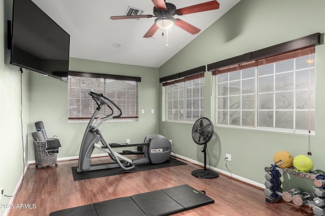 exercise room with lofted ceiling, wood finished floors, baseboards, and visible vents