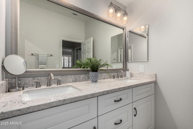 full bathroom with a sink, visible vents, and double vanity