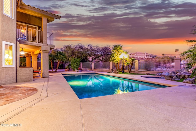 pool at dusk with a fenced in pool, a hot tub, a patio, and fence