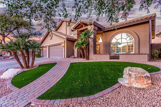 mediterranean / spanish-style home with a front lawn, a tiled roof, concrete driveway, stucco siding, and a garage