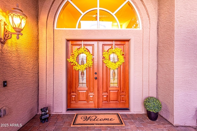 view of exterior entry featuring stucco siding