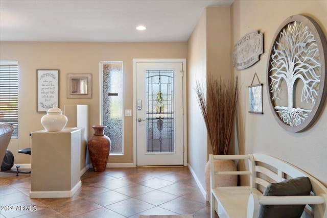 entryway featuring baseboards, plenty of natural light, and tile patterned floors