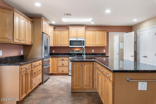 kitchen featuring stainless steel appliances, recessed lighting, visible vents, a kitchen island with sink, and dark stone counters