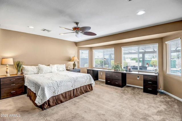 bedroom featuring light colored carpet, visible vents, baseboards, and multiple windows