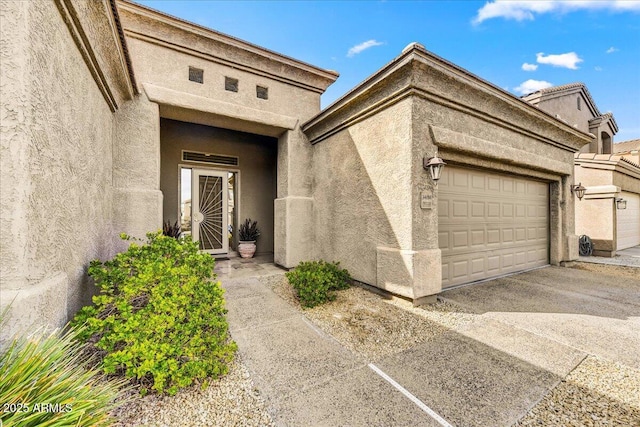 property entrance with stucco siding and an attached garage