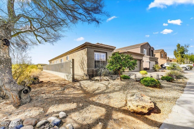 view of home's exterior with fence and stucco siding