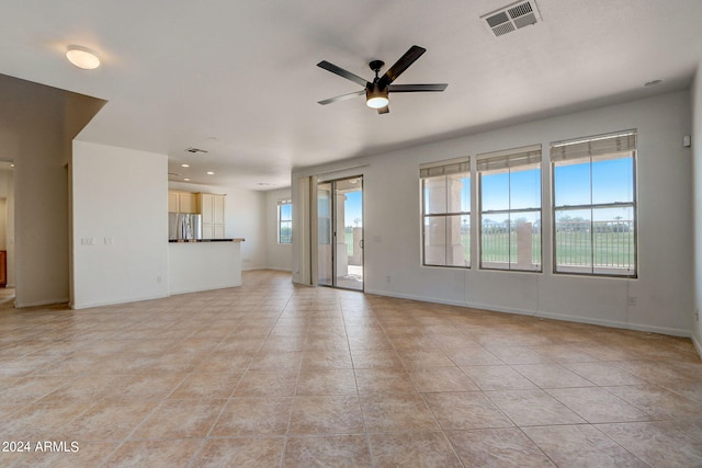 unfurnished living room featuring ceiling fan and light tile patterned floors