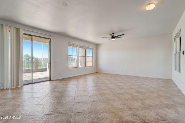 tiled empty room featuring ceiling fan