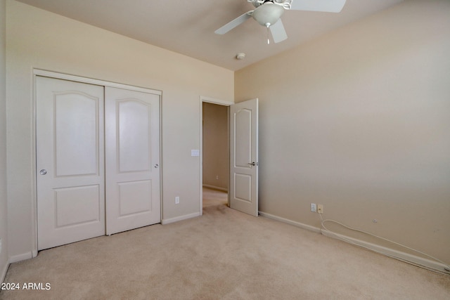 unfurnished bedroom with ceiling fan, a closet, and light carpet