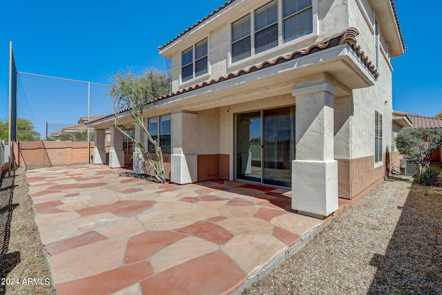 rear view of house featuring central AC unit and a patio