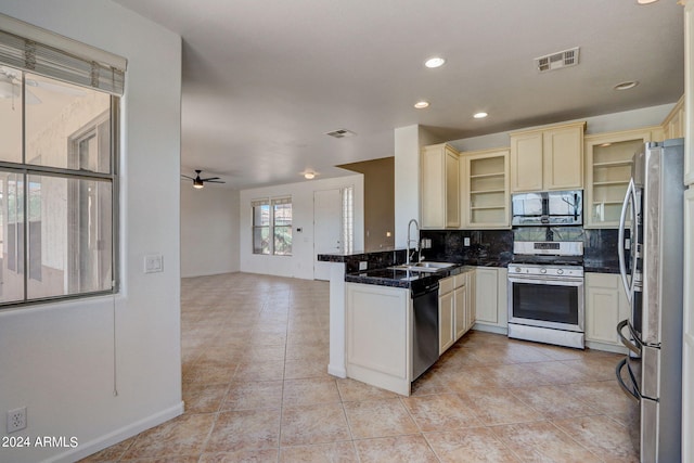 kitchen featuring kitchen peninsula, backsplash, stainless steel appliances, ceiling fan, and sink