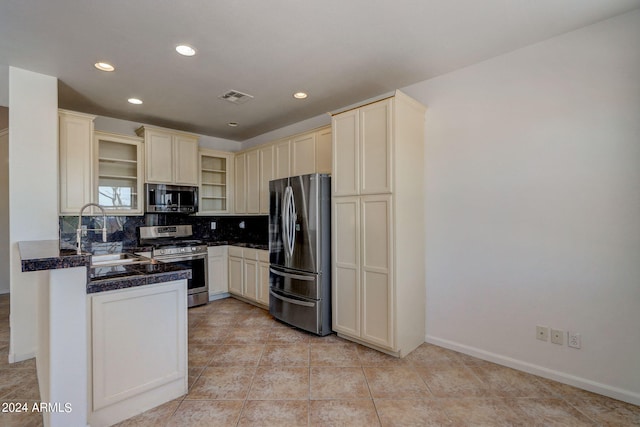 kitchen featuring tasteful backsplash, sink, light tile patterned floors, and stainless steel appliances