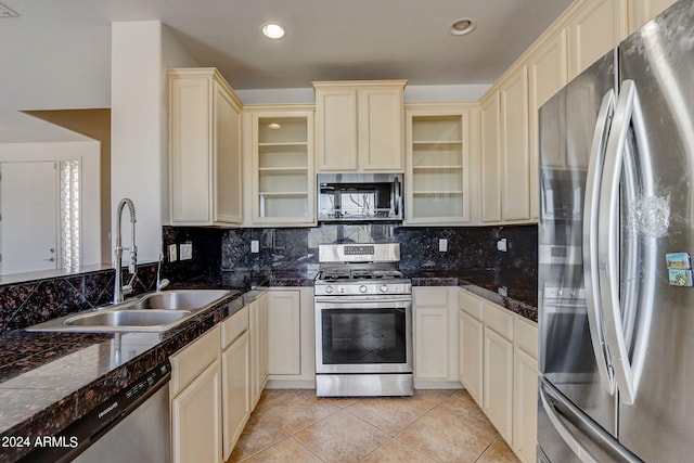 kitchen featuring cream cabinetry, light tile patterned floors, stainless steel appliances, and sink