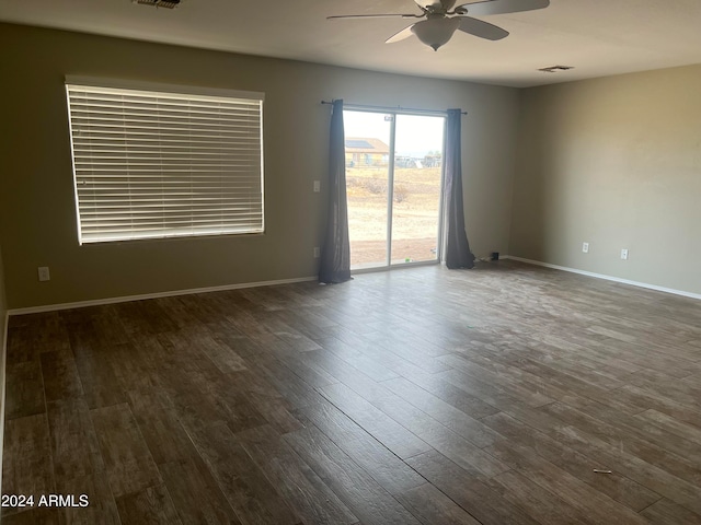 empty room with ceiling fan and dark hardwood / wood-style floors