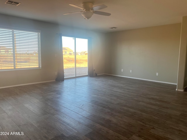 spare room featuring dark wood-type flooring and ceiling fan