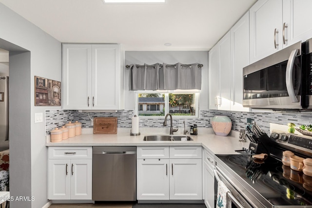 kitchen featuring tasteful backsplash, appliances with stainless steel finishes, sink, and white cabinets