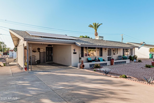 ranch-style house with solar panels and covered porch