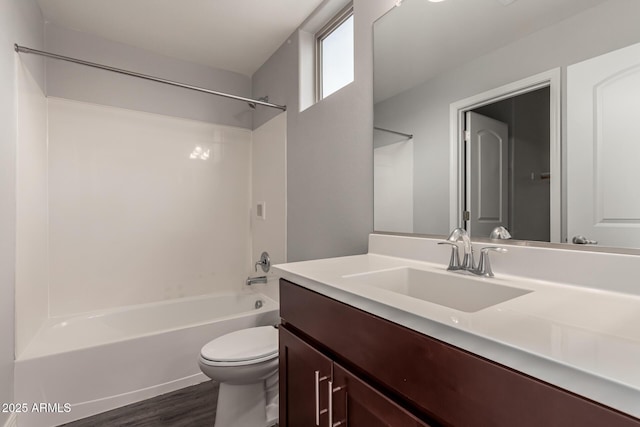 full bathroom featuring hardwood / wood-style floors, vanity, toilet, and washtub / shower combination